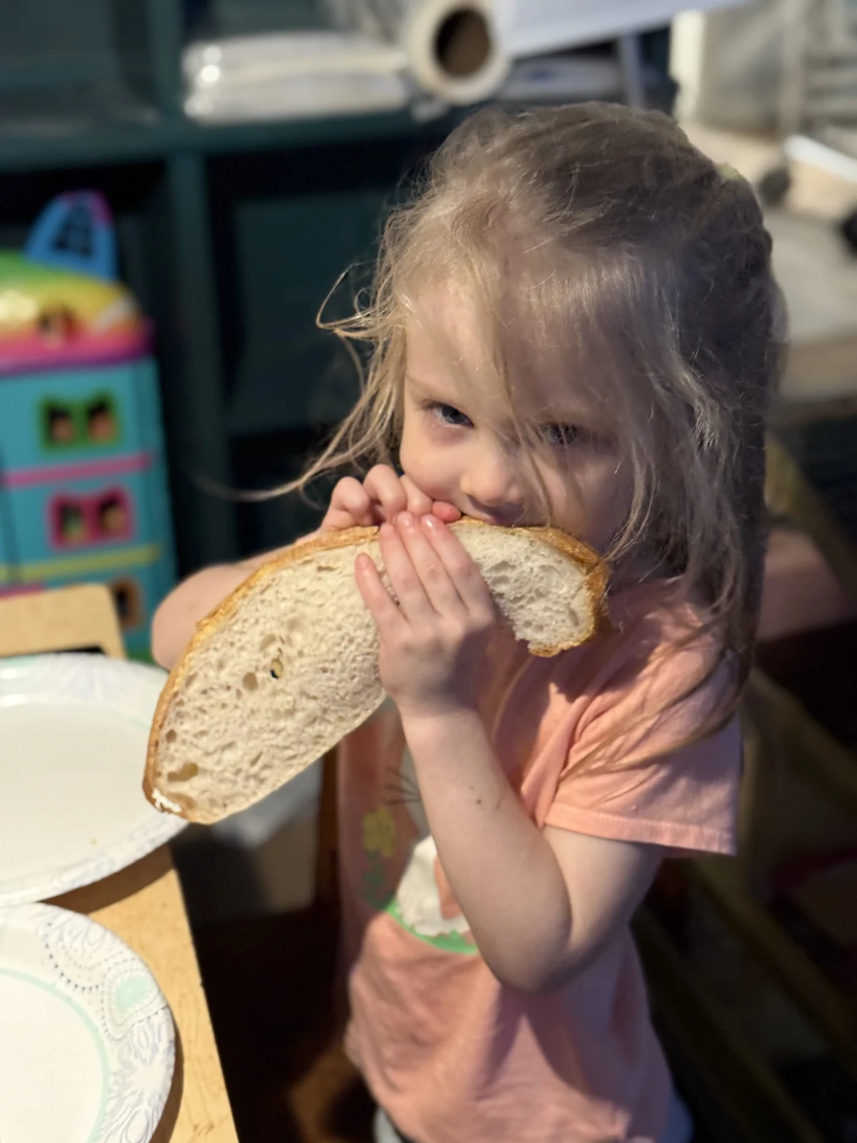 A child enjoying a generous slice of sourdough at home